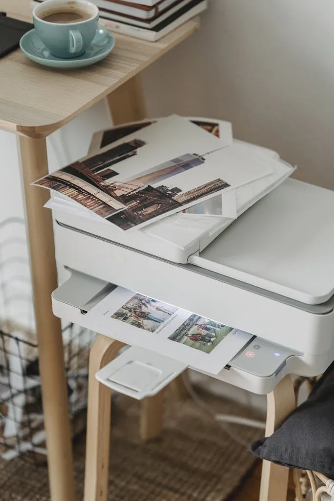Home Office Essentials - Photos placed on printer near table with cup of coffee